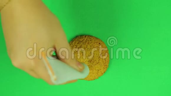 这个孩子在欧元符号饼干上画了一个绿色背景的棕色糖霜时间跨度视频的预览图