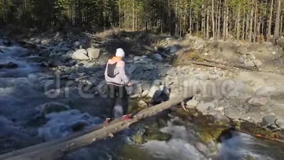 女人在大自然中行走北欧女人正沿着一座木头桥走女孩用跋涉棒和北欧视频的预览图