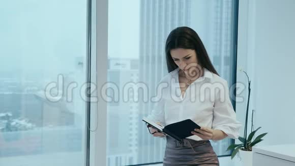 女商人在玻璃办公室里拿着日历视频的预览图