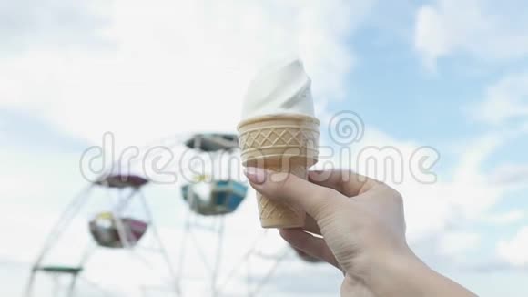 女人手拿着冰淇淋在观察轮背景童年的回忆视频的预览图