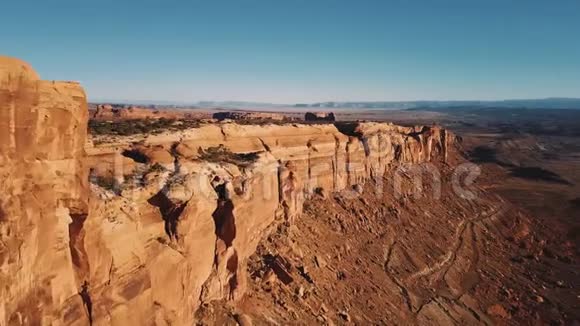 无人机在雄伟的平顶山峡谷山脊上方展开史诗般地俯瞰着美国阳光明媚的沙漠天际线视频的预览图