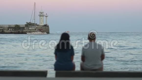 两位成年朋友在海堤上眺望大海或大海视频的预览图