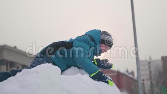 一个少年在雪山之上抛雪而笑晴朗的霜天新鲜空气中的乐趣和游戏视频的预览图