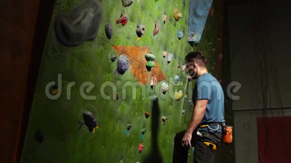 一个登山者开始攀登岩体的墙在岩石上投保职业运动员视频的预览图