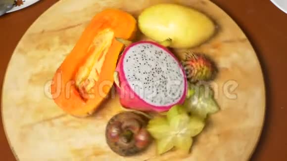 餐桌上的异国水果4K俯视慢运动杨桃火龙果木瓜芒果龙眼视频的预览图