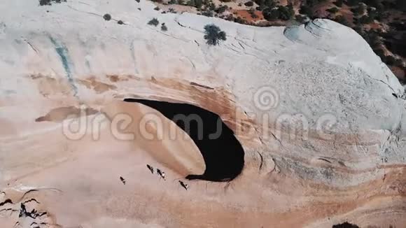 无人机飞行在巨大的白色岩石组与大洞游客步行在亚利桑那州山区沙漠景观视频的预览图