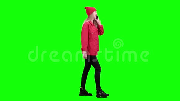 年轻时尚的女孩走在街上打电话绿色屏幕侧视图视频的预览图