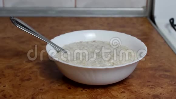 烹饪燕麦片一个女人倒糖麦芽燕麦片关门早餐视频的预览图