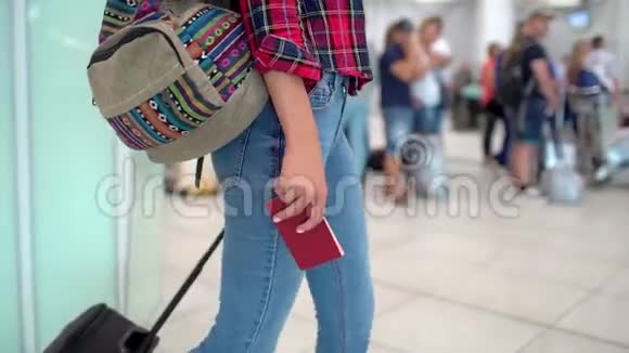 穿着休闲衬衫的旅行妇女手里拿着护照走在现代机场候机楼里视频的预览图