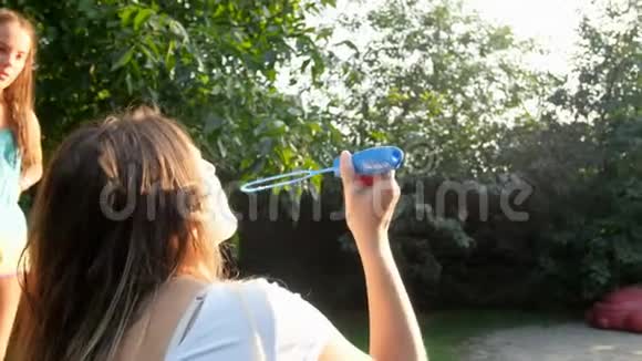 公园里带着孩子吹肥皂泡的快乐小家庭慢动作视频视频的预览图