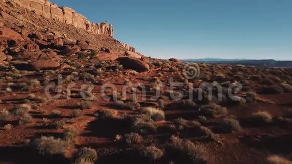 无人机在巨大的山脉附近低空飞行亚利桑那州的砂岩景观覆盖着岩石和阳光明媚的天空视频的预览图