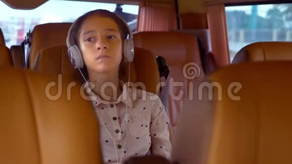 暑假概念旅游少女乘坐带耳机的小型货车视频的预览图