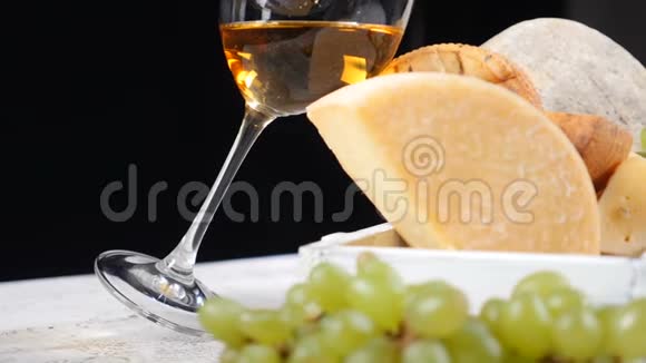 葡萄酒和奶酪的概念食品艺术概念奶酪爱好者各种奶酪放在黑色背景的木板上视频的预览图