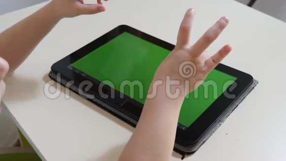 那个小男孩正在玩平板电脑绿色屏幕从上面看视频的预览图
