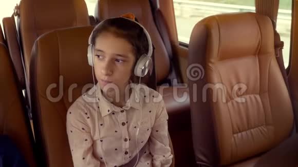 暑假概念旅游少女乘坐带耳机的小型货车视频的预览图