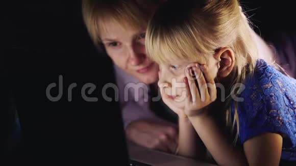 母女俩躺在床上用笔记本电脑面对面一切都是一起做的概念视频的预览图