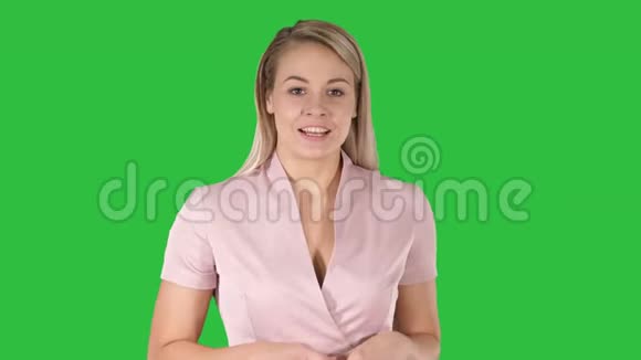 穿粉色衣服的女人在绿色屏幕上和摄像机说话Chroma键视频的预览图