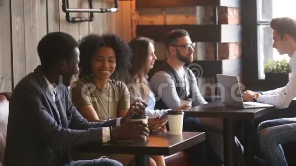 坐在咖啡屋桌子上说话的非洲青年男女视频的预览图