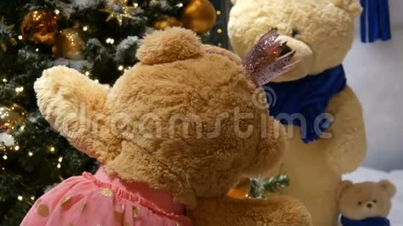 公主玩具棕色泰迪熊穿着连衣裙戴着皇冠在圣诞装饰的购物中心转悠视频的预览图