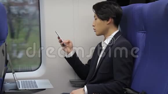 一张韩国商人的画像他在乘火车旅行时在手机上输入信息视频的预览图