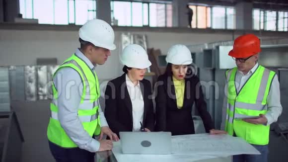 自信的女工程师或建筑师与男性同事讨论建筑问题绿色背心视频的预览图