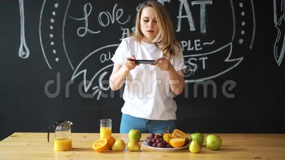 女拍照健康食品水果桌上的橙汁视频的预览图