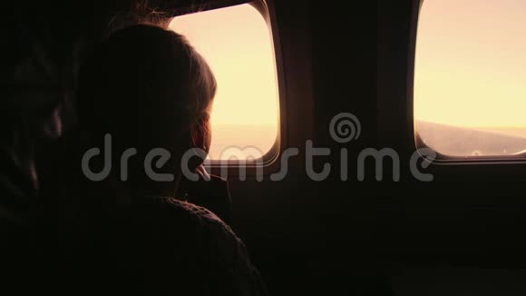 坐在飞机上的女孩望着窗外升起的太阳视频的预览图