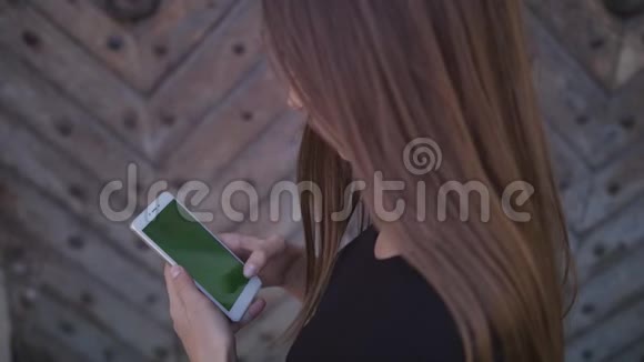 一个人使用带有触摸绿色屏幕的蜂窝电话浏览社交网络和通信特写女孩视频的预览图