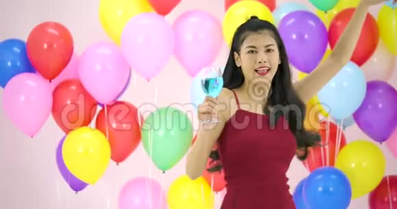在晚会上美丽的亚洲女人在慢动作中带着五颜六色的气球背景跳舞视频的预览图