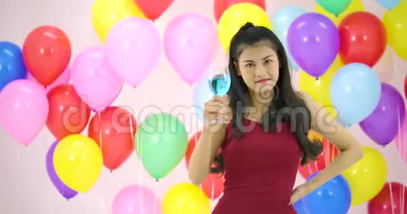 在晚会上美丽的亚洲女人在慢动作中带着五颜六色的气球背景跳舞视频的预览图