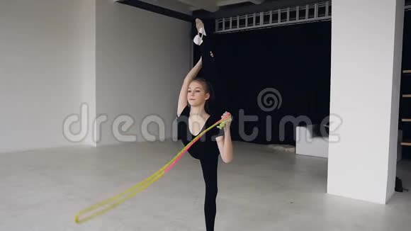体操学校和能量穿黑色运动服的女体操运动员用绳子分开杂技和健身的灵活性视频的预览图