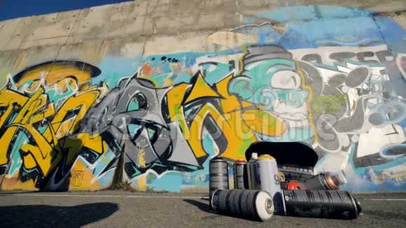 涂鸦艺术家来到墙上开始画灰色背包在前景视频的预览图