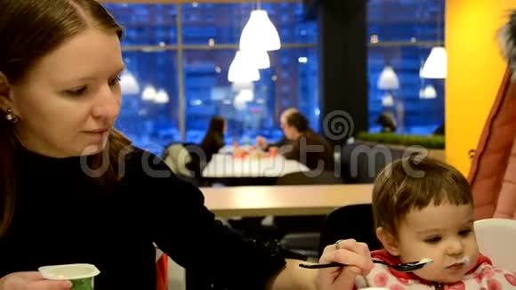 妈妈在咖啡馆里喂孩子家庭食物孩子饮食和父母的概念母亲与纯净和勺子视频的预览图