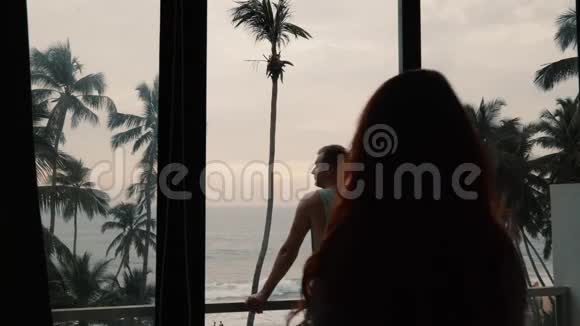 一对情侣在露台上看海的剪影视频的预览图