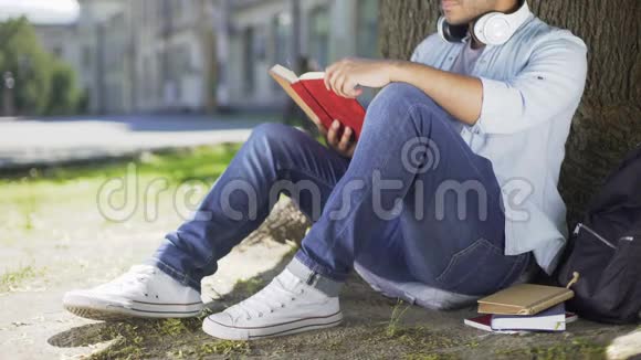 跨国公司的人坐在树下看书爱书闲暇时间视频的预览图