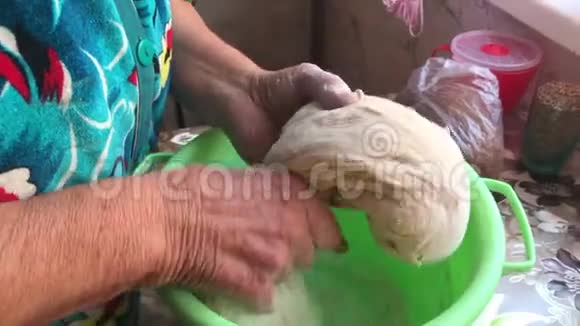 一位老太太揉面包面团放在烤盘上你可以看到她的手在工作视频的预览图