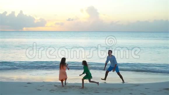 一家人在日落时享受海滩时光流动人口视频的预览图