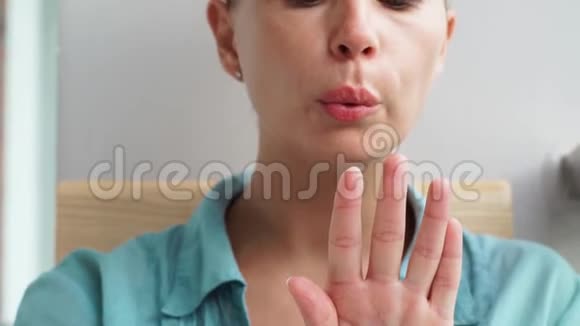 年轻女子吹干指甲油后应用女晒指甲漆时上门修指甲家庭修指甲视频的预览图