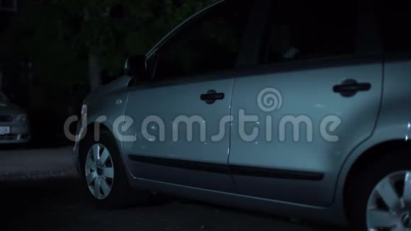 手拿刀的犯罪阴影反射在停放的汽车表面劫车视频的预览图