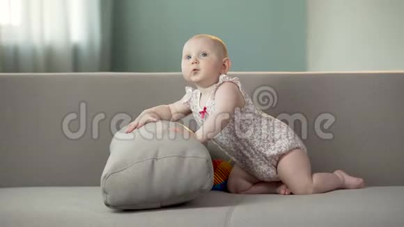 有趣的快乐女婴在沙发上跳跃在舒适的尿布中发现世界视频的预览图
