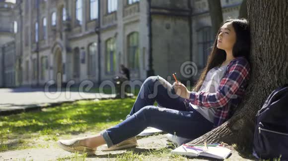 多国年轻女子平静地坐在树下闭着眼睛放松视频的预览图