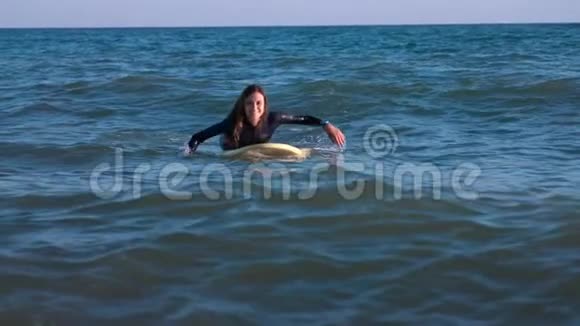 美丽苗条的女孩漂浮在海里的冲浪板上专业的海上服务人员视频的预览图
