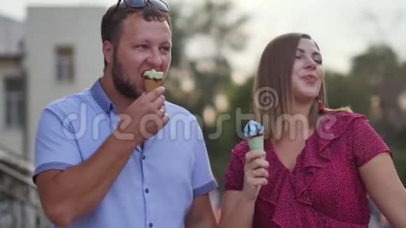 快乐的一对夫妇在夜城散步吃冰淇淋慢动作视频的预览图