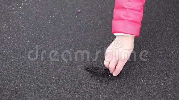 女孩在黑沙上画了一颗心可见画手的心视频的预览图