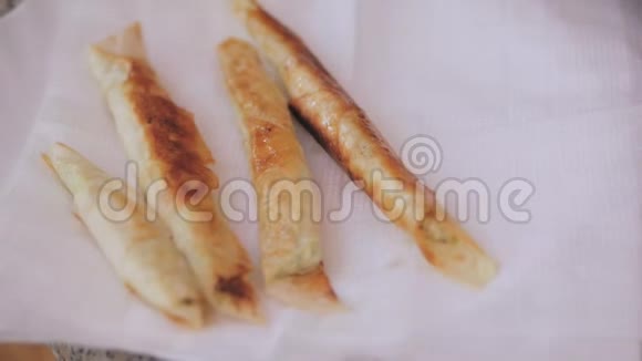 准备土耳其民族菜肴西加拉伯尔吉女人的手把准备好的菜摊在盘子里视频的预览图
