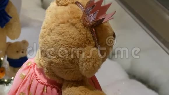 公主玩具棕色泰迪熊穿着连衣裙戴着皇冠在圣诞装饰的购物中心转悠视频的预览图
