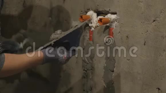 人手用子抹灰一面墙建筑工人在工作建筑工人用刀把墙打平视频的预览图