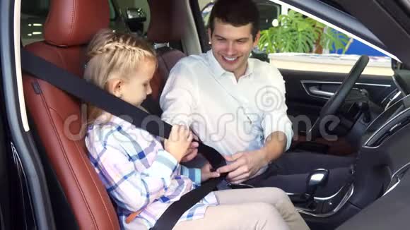 有爱心的父亲把女儿安全带系在车上视频的预览图