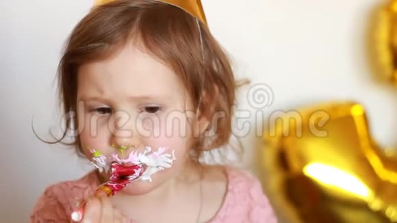 描绘一个有趣的小女孩她吃了一个美味的蛋糕快乐的孩子脸上有一张脏兮兮的甜点视频的预览图