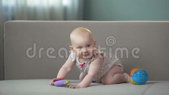 健康的宝宝在沙发上跳玩五颜六色的玩具享受快乐的生活视频的预览图